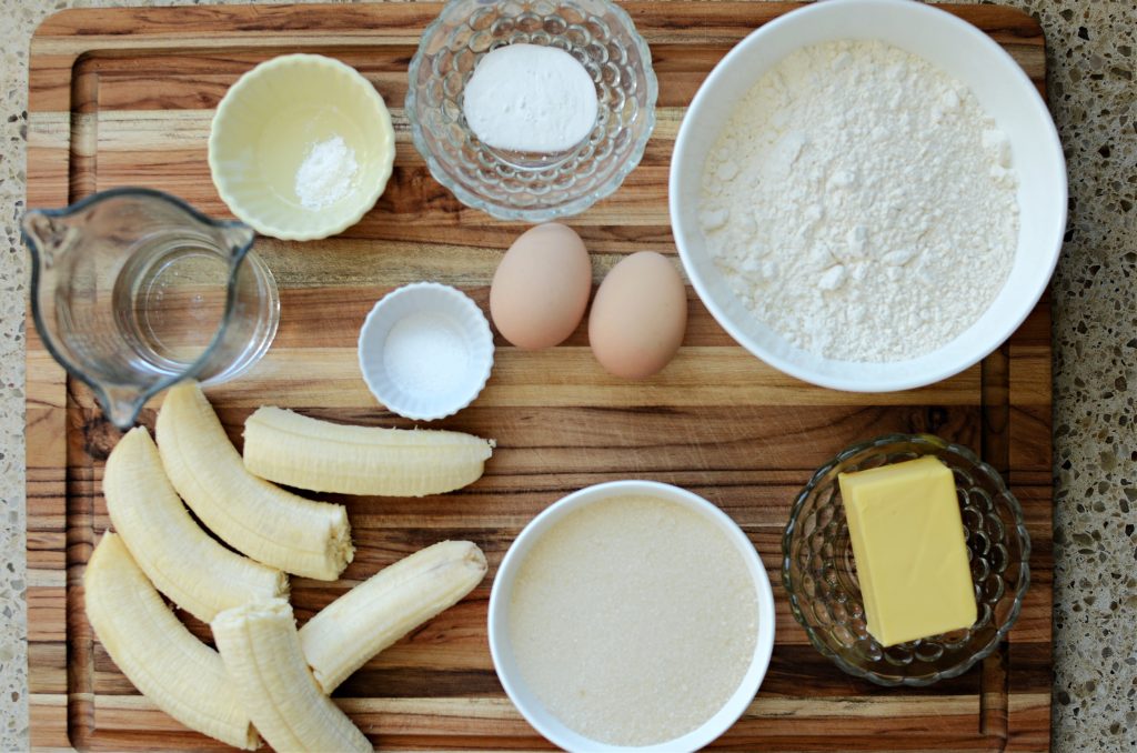 Banana bread ingredients on wood cutting board