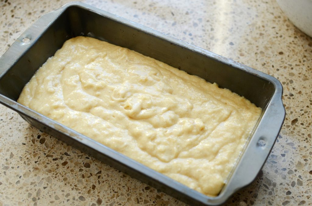 Metal loaf pan filled with banana bread batter