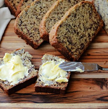 sliced banana bread with butter on wooden cutting board