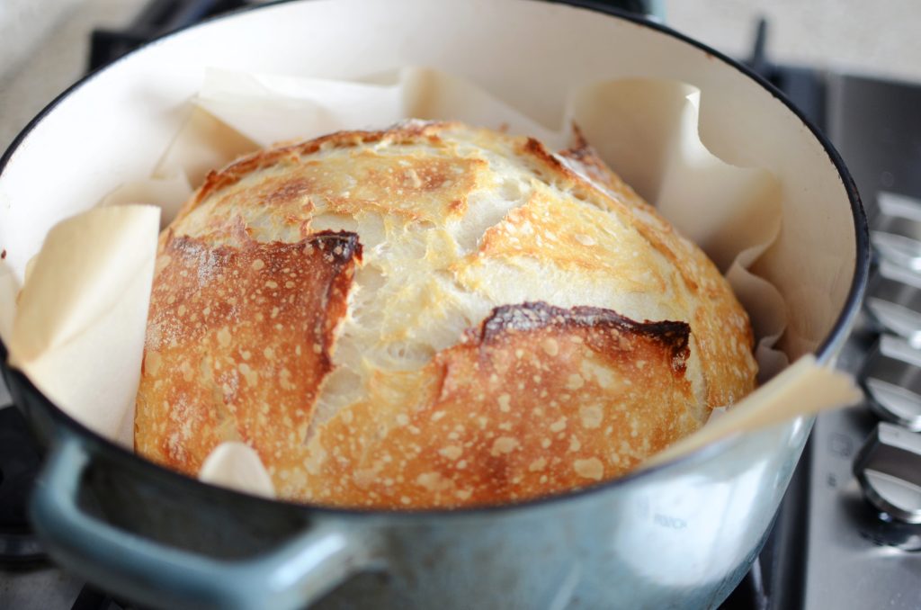 Baked sourdough loaf in dutch oven.