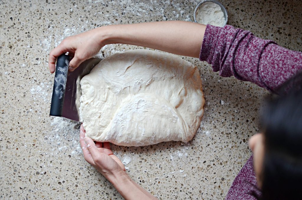 lifting sourdough dough with metal bench scraper