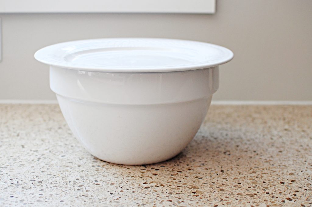 White bowl with white plate resting on top