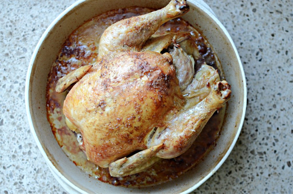 Roast chicken in round stoneware pan