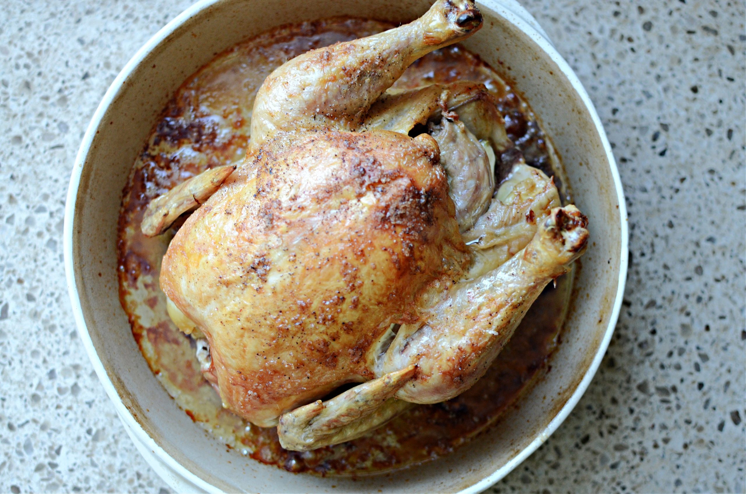 Roast chicken in round stoneware pan