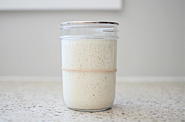 sourdough starter in mason jar with rubber band around the jar