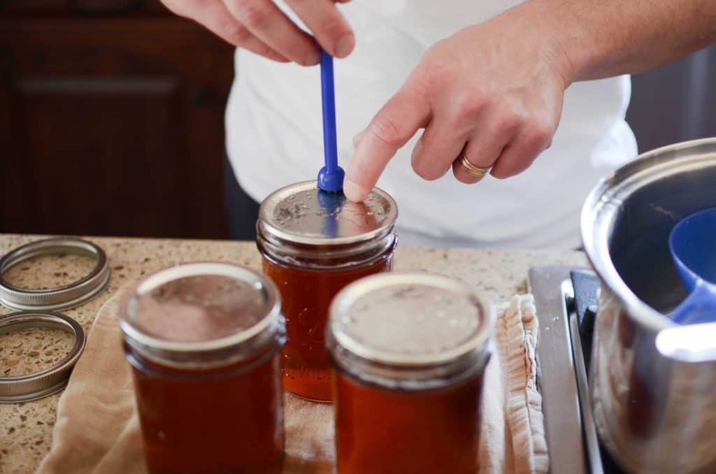 placing lid on mason jar with lid lifter