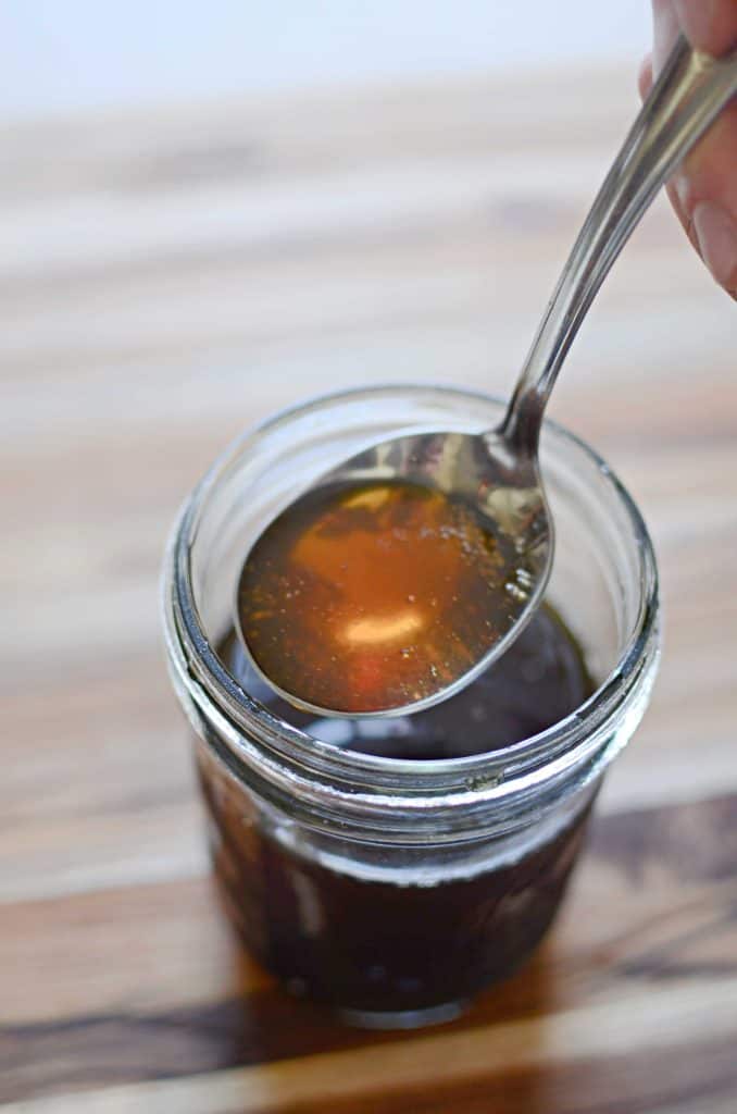 spoon ladling maple syrup from mason jar