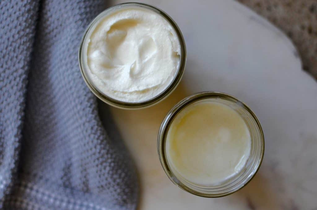 two jars of tallow balm with a grey hand towel