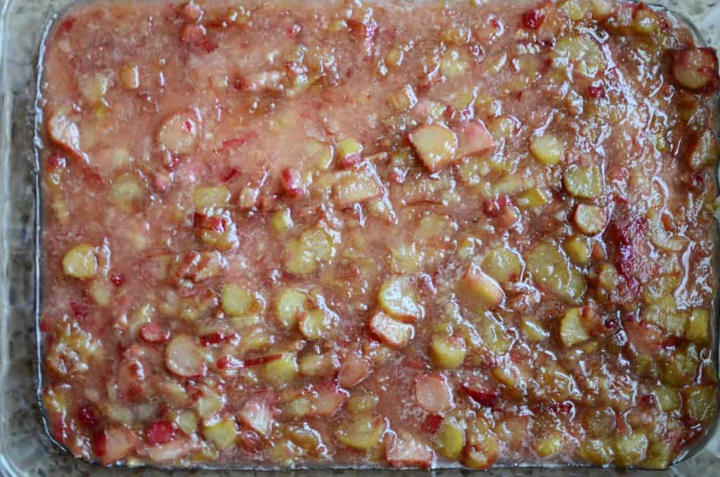 Cooked rhubarb spread over crumble mixture in 9X13 pan