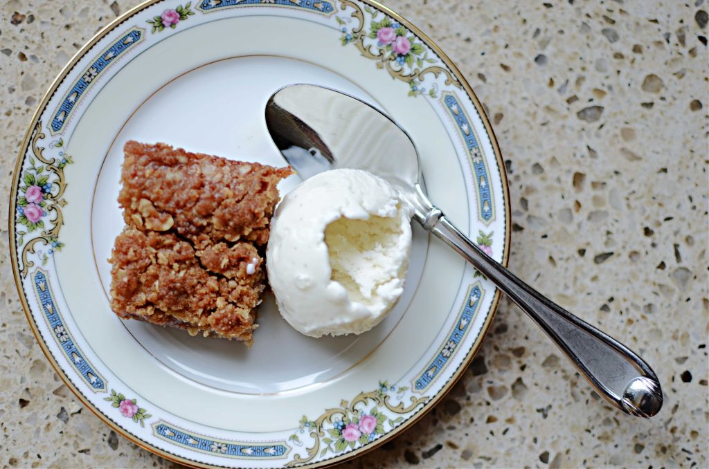 Rhubarb bar on plate with scoop of vanilla ice cream and spoon