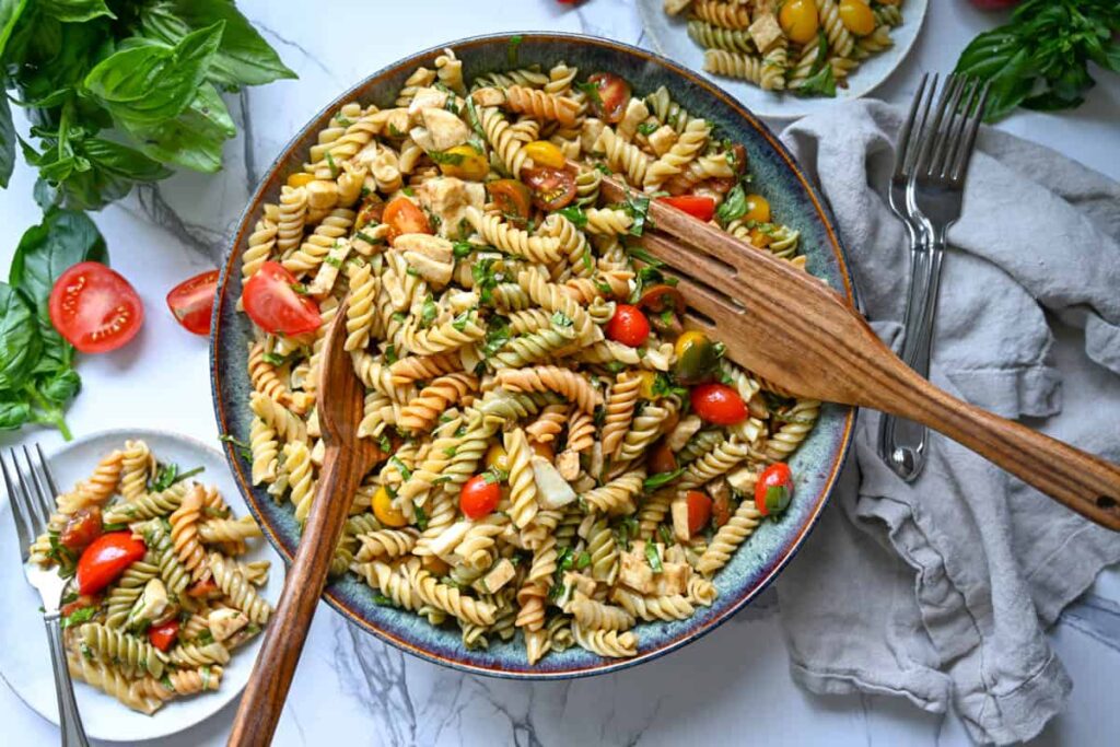 Easy caprese pasta salad in a large bowl with a wood serving spoon