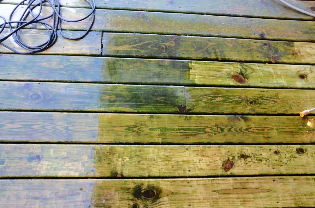 Deck with algae being power washed