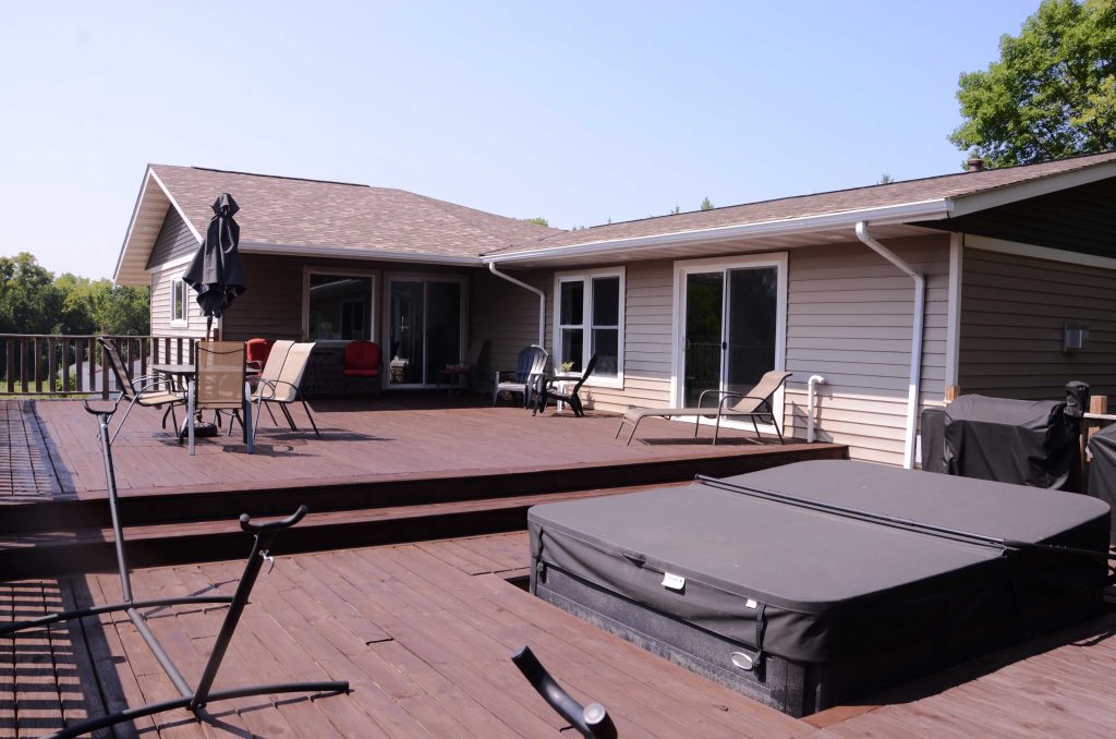 Deck with deck furniture, hot tub and house