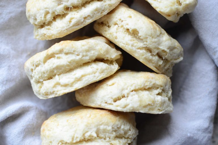 Buttermilk biscuits staggered stacked with linen towel behind