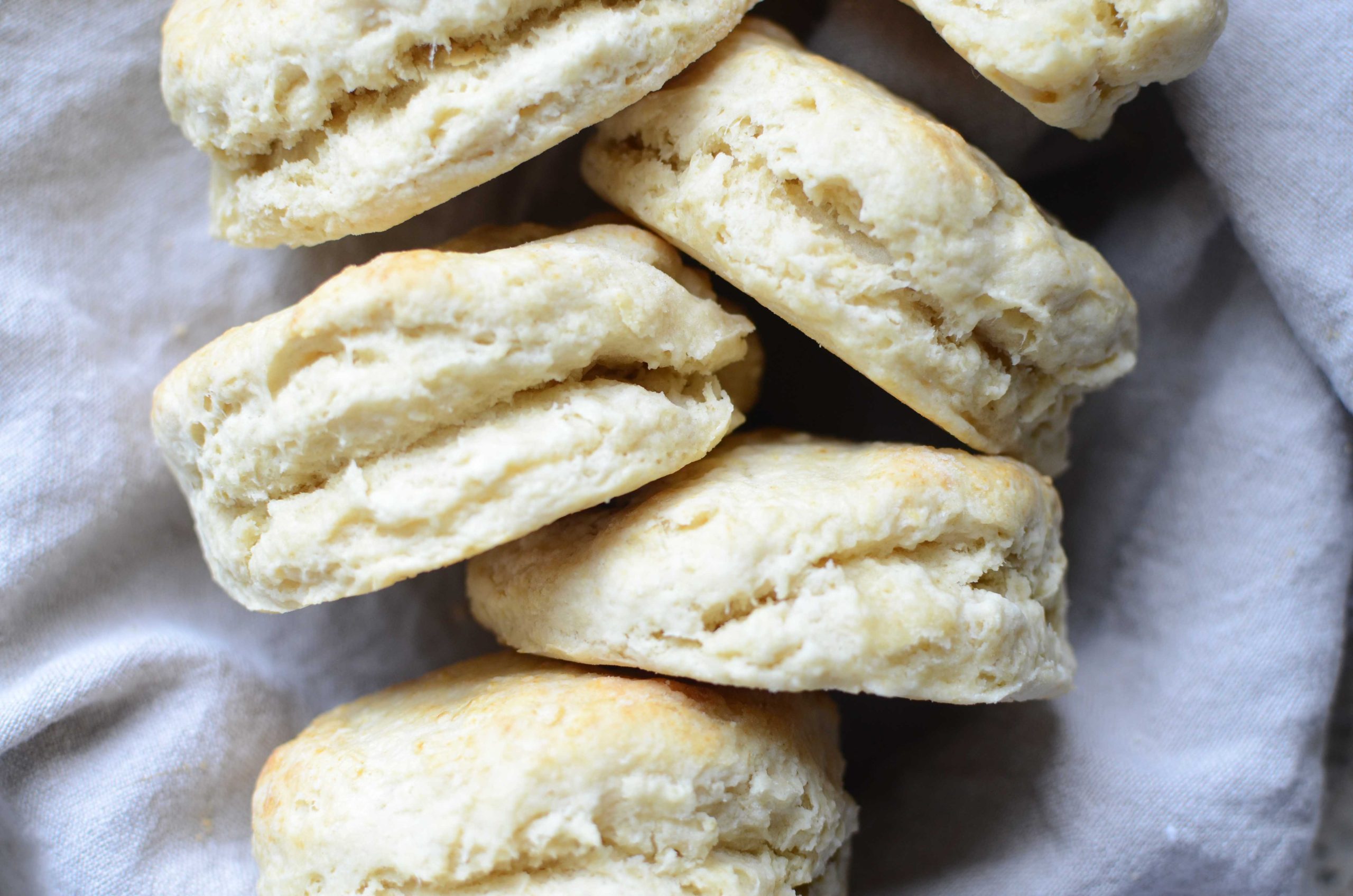 Buttermilk biscuits staggered stacked with linen towel behind