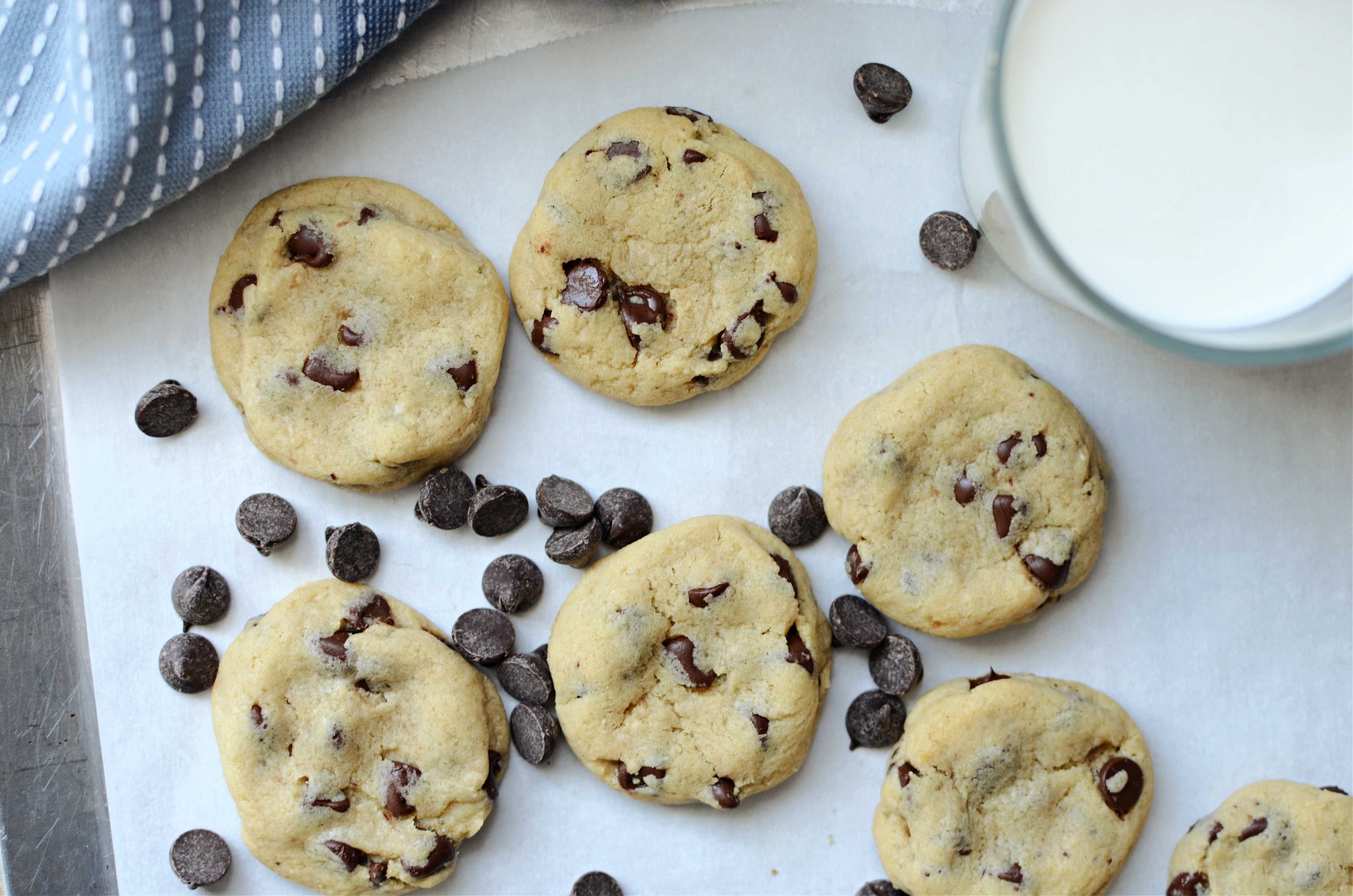 Soft batch chocolate chip cookies with chocolate chips scattered around cookies