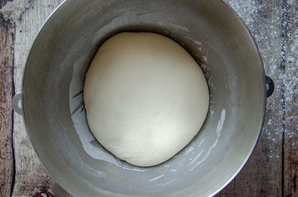 sourdough English muffin dough in metal bowl after bulk fermentation