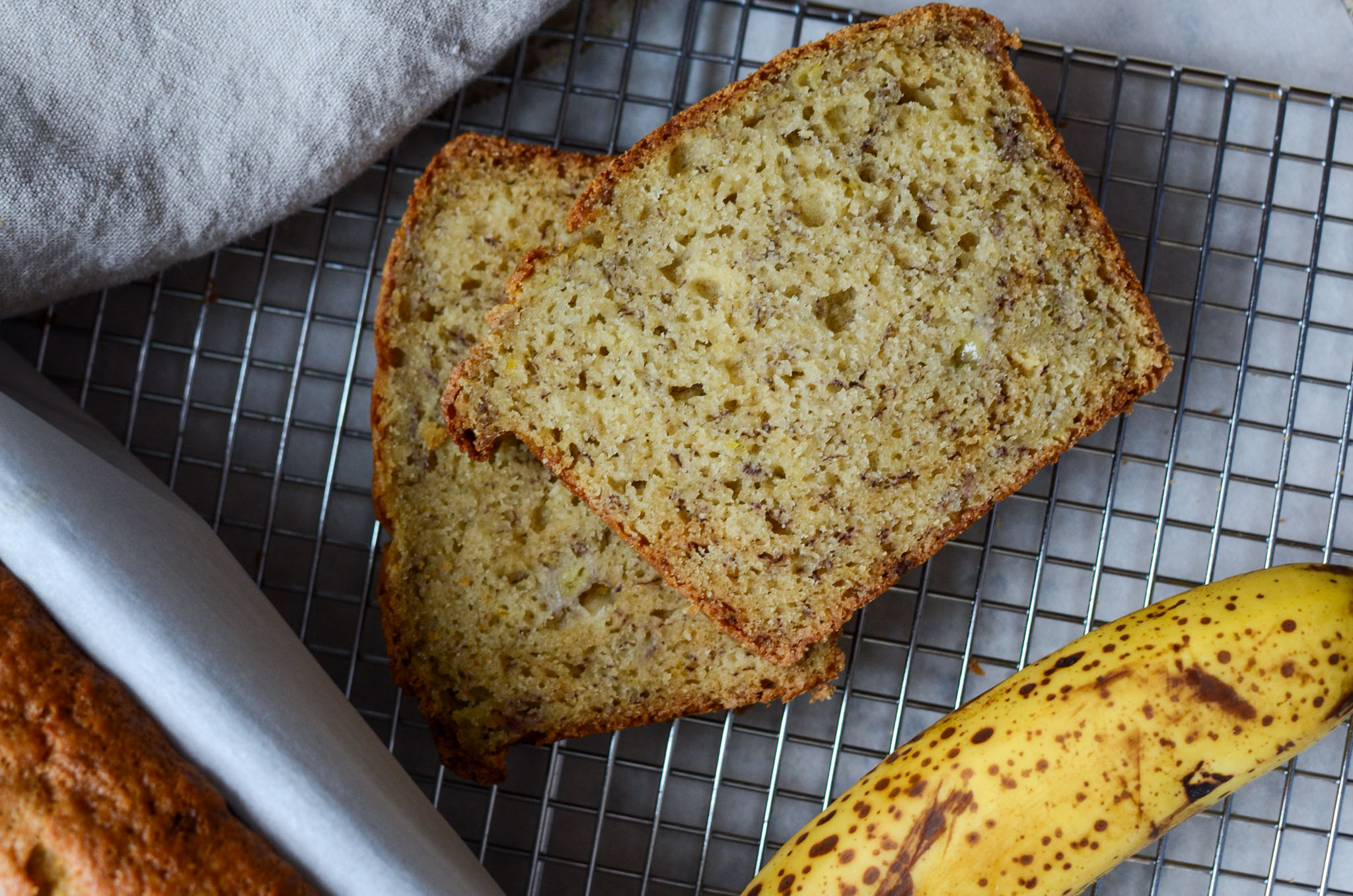 two slices of sourdough banana bread on a wire cooling rack