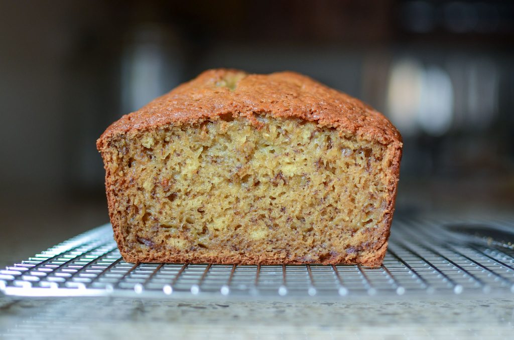 sourdough banana bread loaf sliced open on wire rack