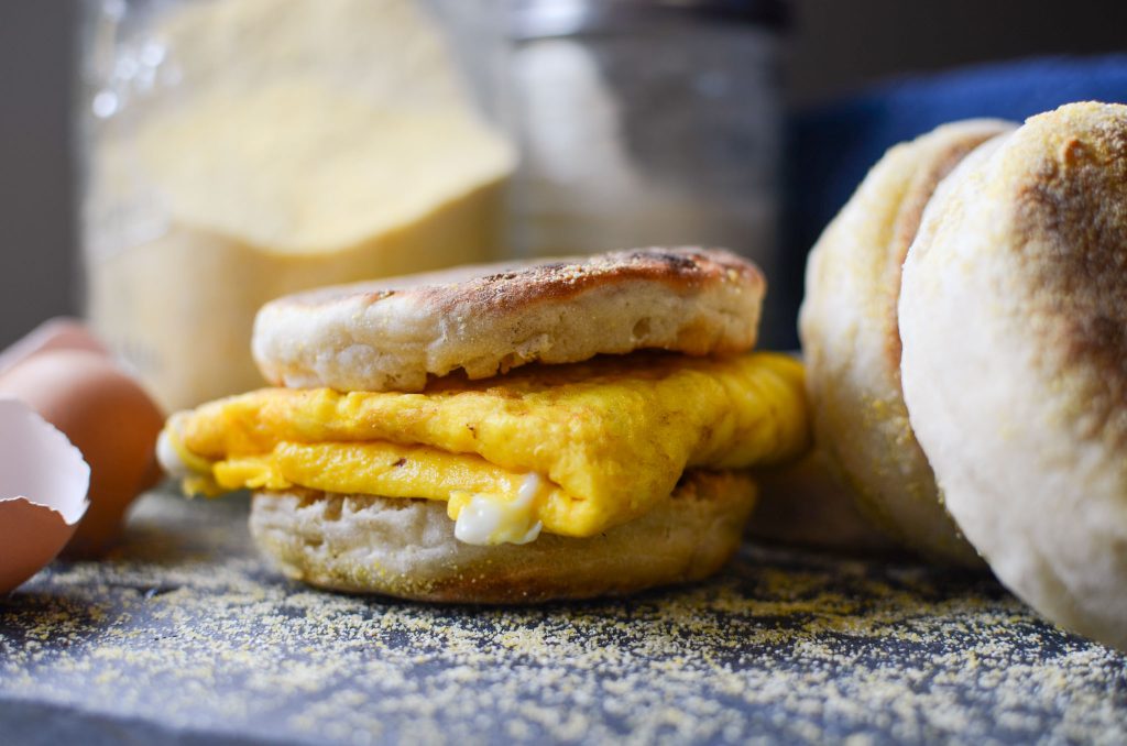 sourdough English muffin egg sandwich with other sourdough English muffins next to it