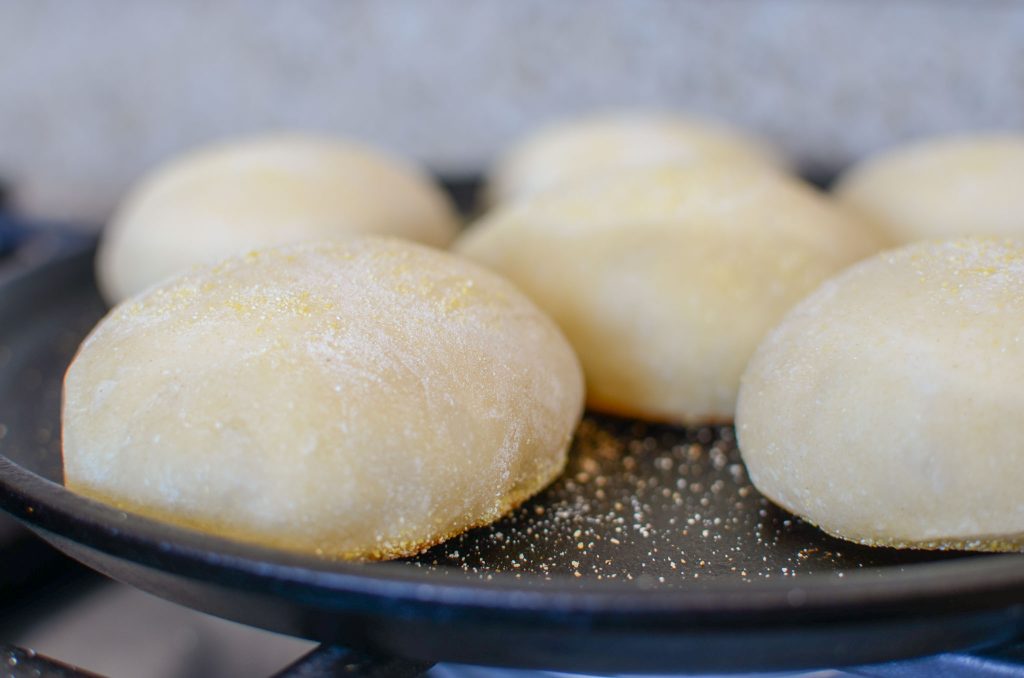 Cooking 1st side of sourdough English muffins on cast iron pan