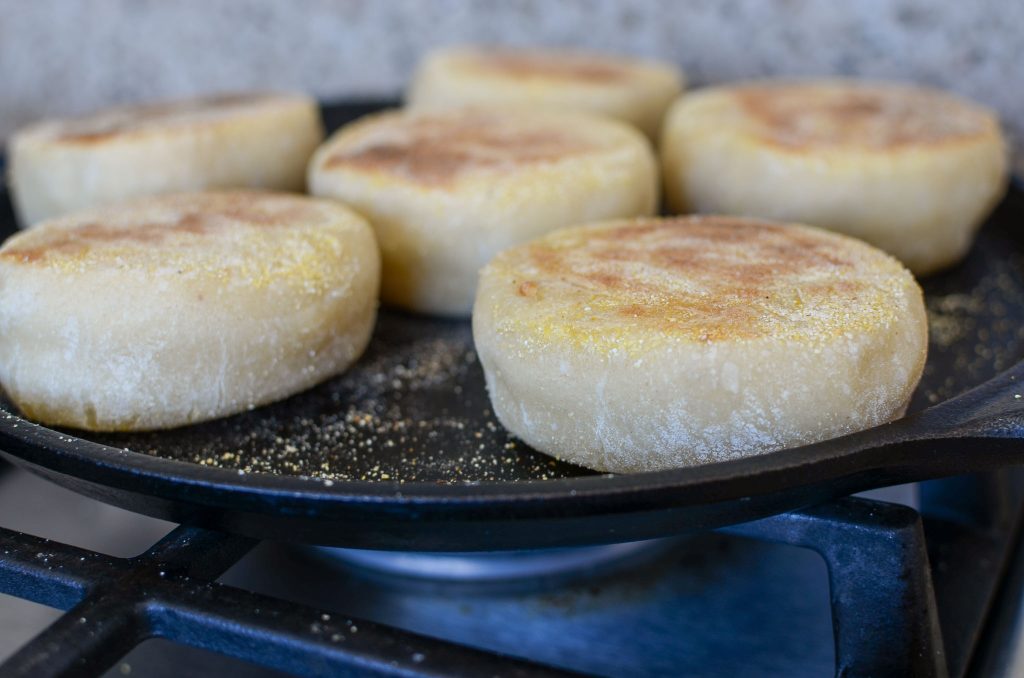 Cooking 2nd side of sourdough English muffins on cast iron pan.