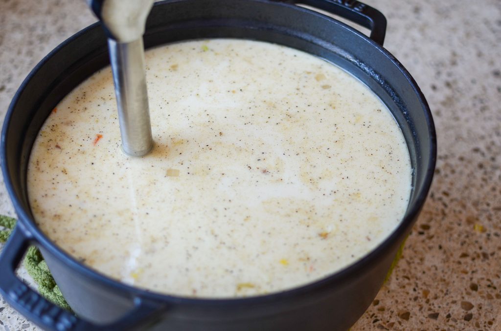 Immersion blender in pot of soup