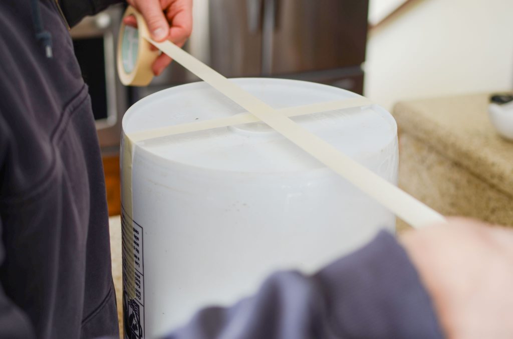 placing masking tape over 5 gallon bucket bottom