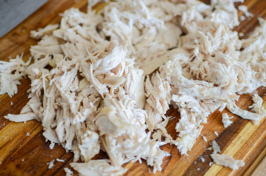 shredded chicken on a wooden cutting board