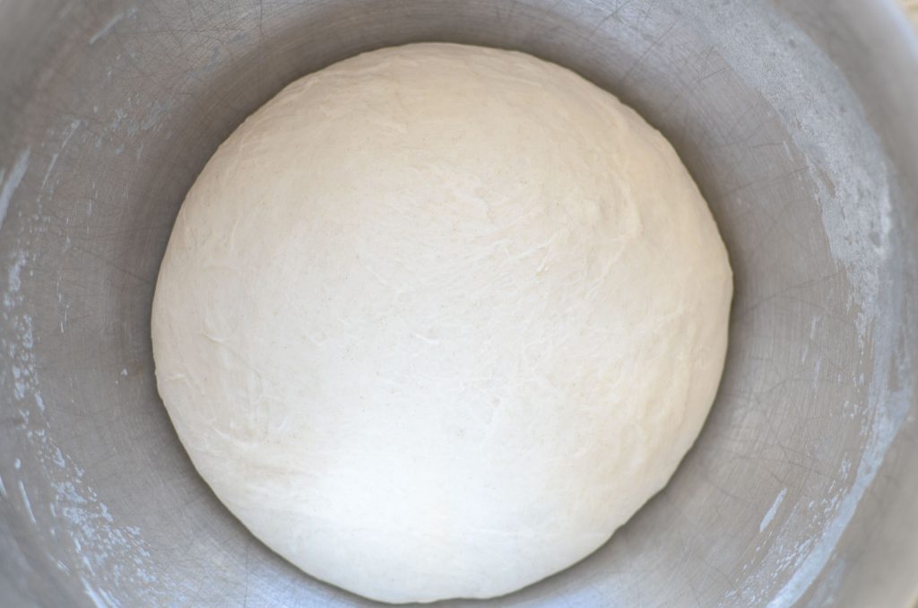 sourdough bagel dough in metal mixing bowl