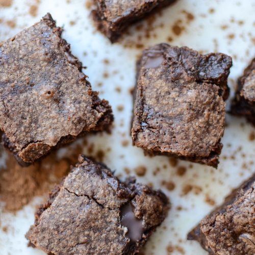 One-Bowl Fudgy Sourdough Brownies on marble with dusted cocoa powder