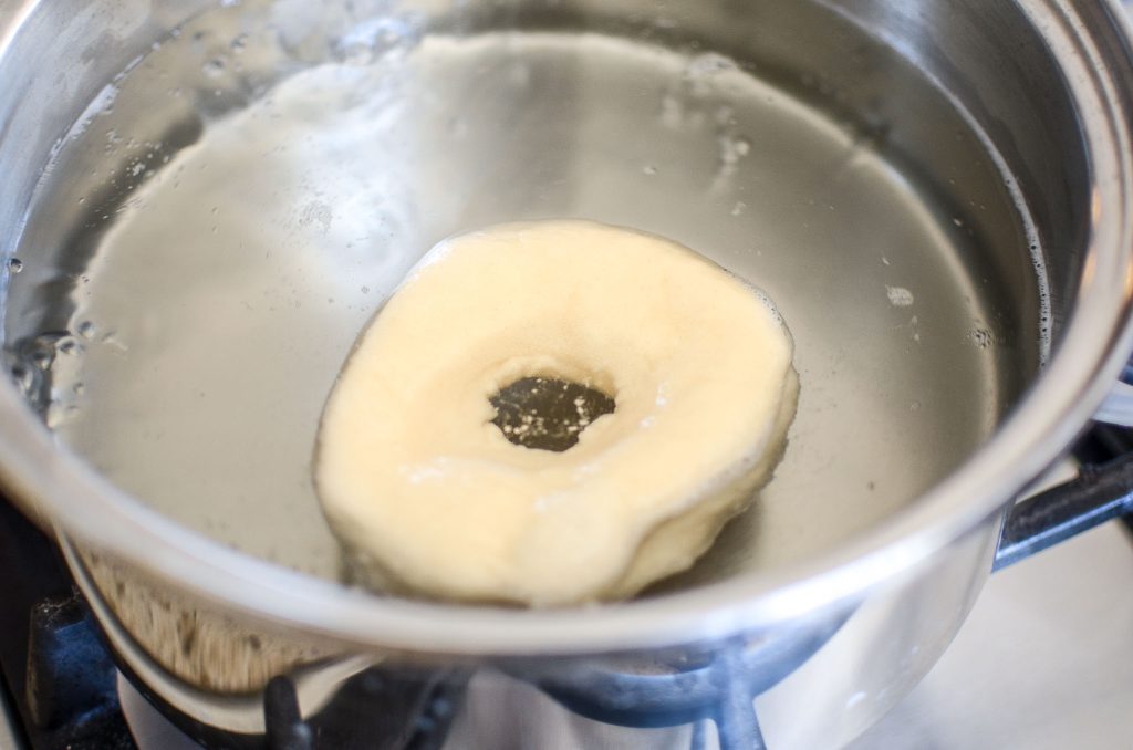 a sourdough bagel into boiling water