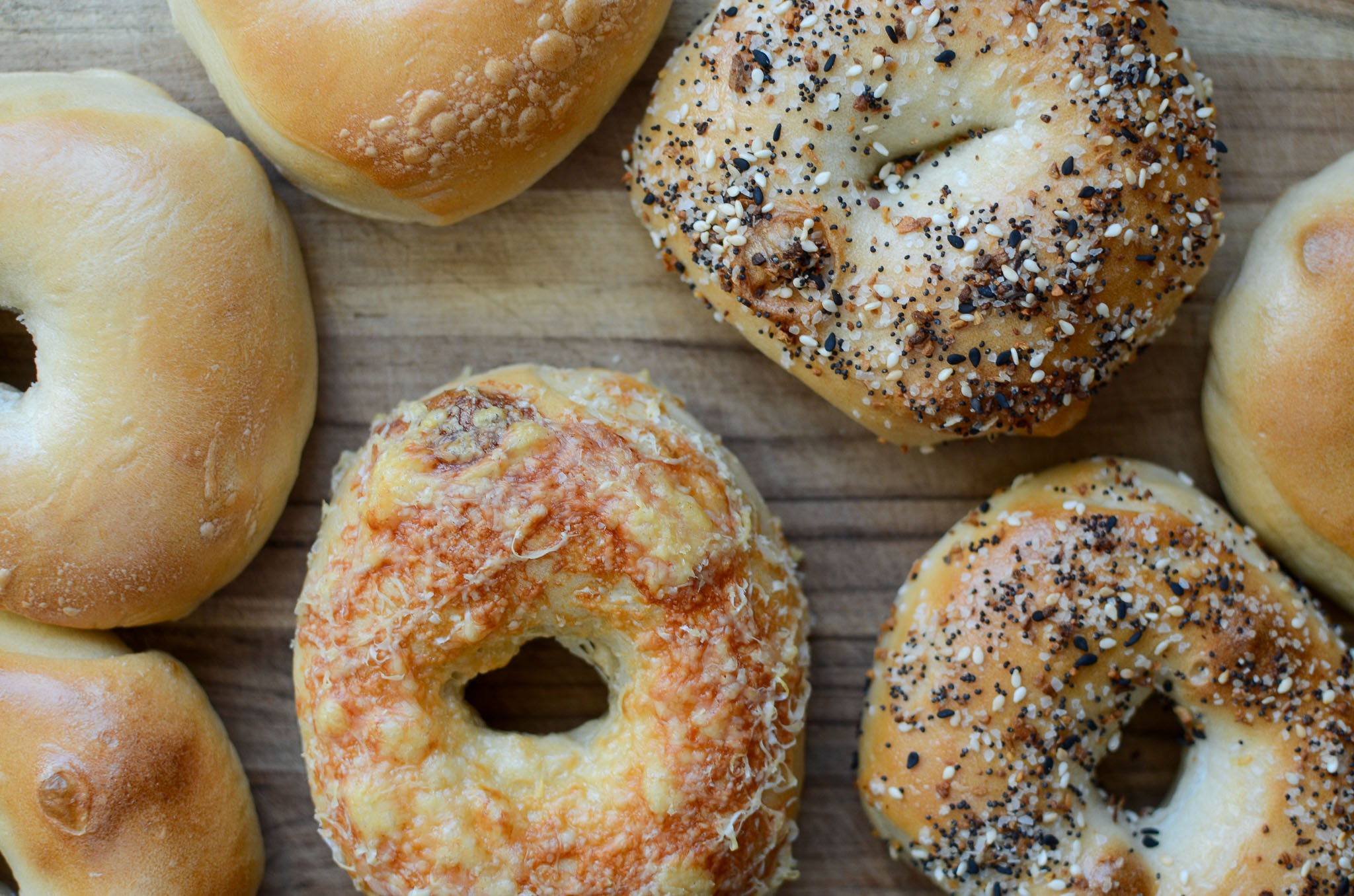 sourdough bagels with various toppings on cutting board