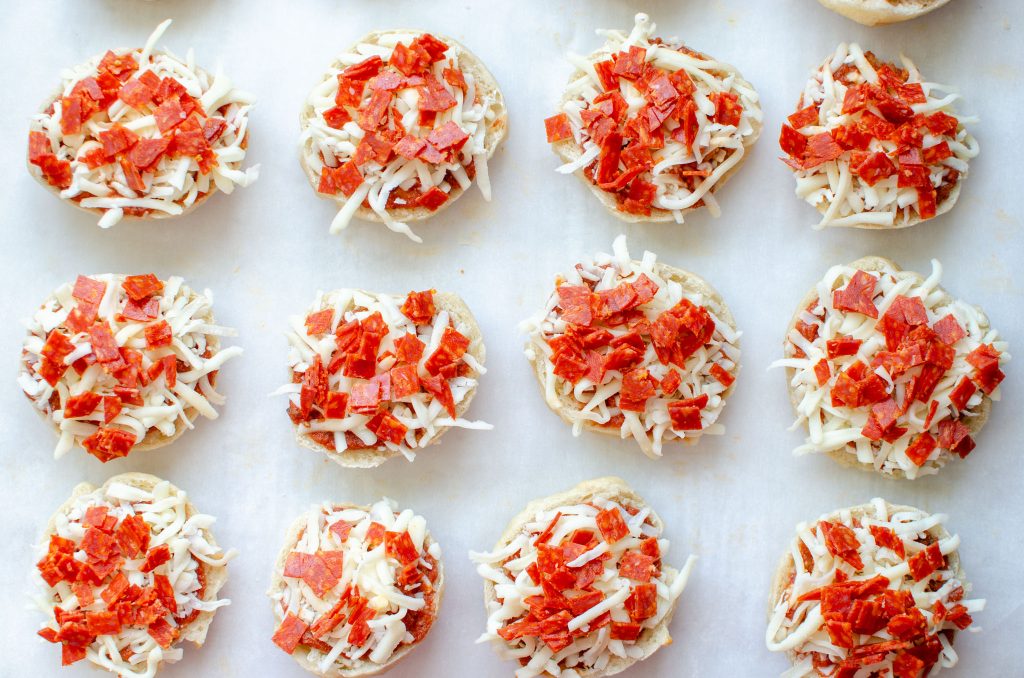 uncooked bagel bites with sauce, shredded mozzarella cheese and diced pepperoni
