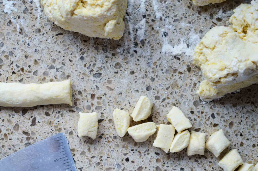 ricotta gnocchi dough rolled into a long rope and cut with a bench cutter