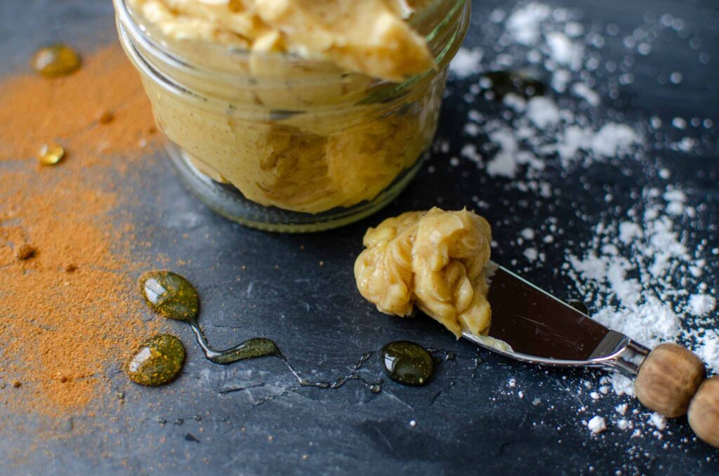 a jar and spreader full of whipped honey butter.