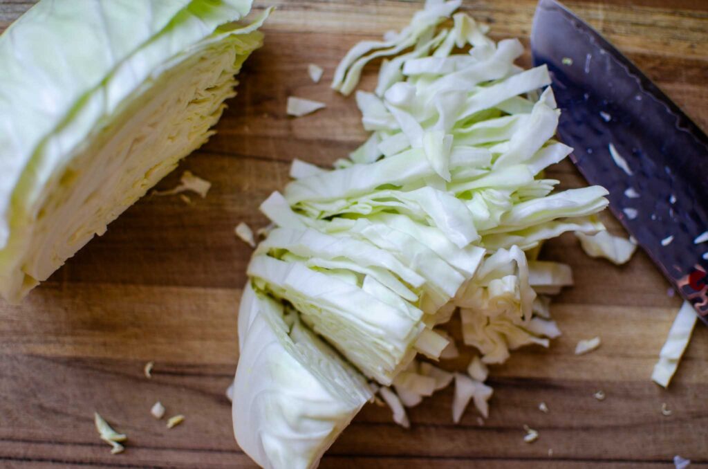 Shredded cabbage on a wood-cutting board for sauerkraut