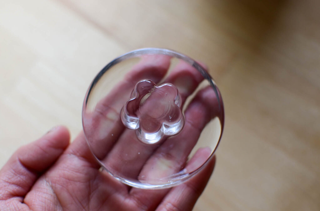 glass fermentation weight held in hand