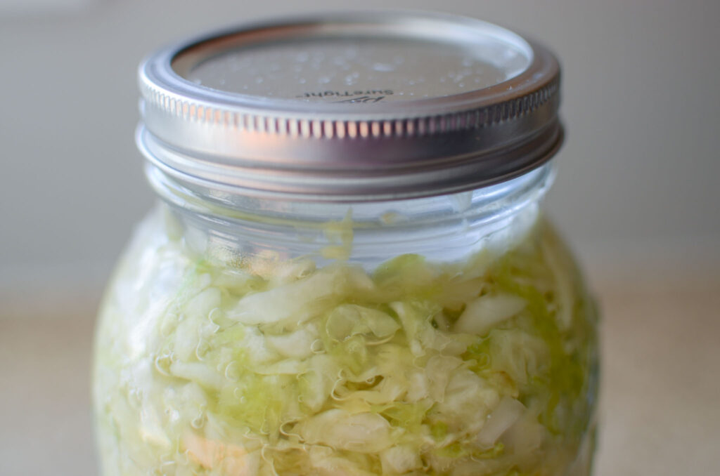 bubbles in a mason jar of Probiotic Rich Homemade Fermented Sauerkraut 