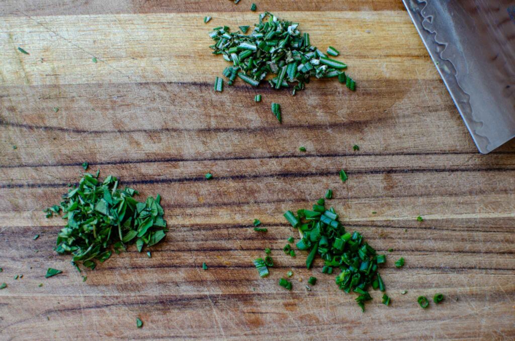 minced herbs on wood cutting board