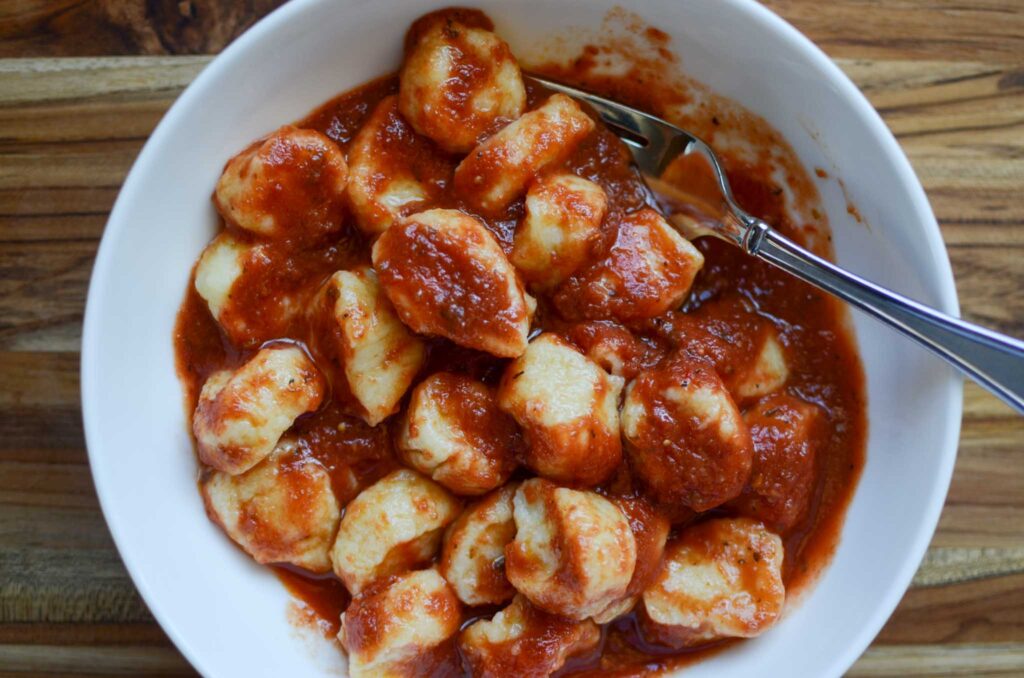 ricotta gnocchi with red tomato sauce in white bowl