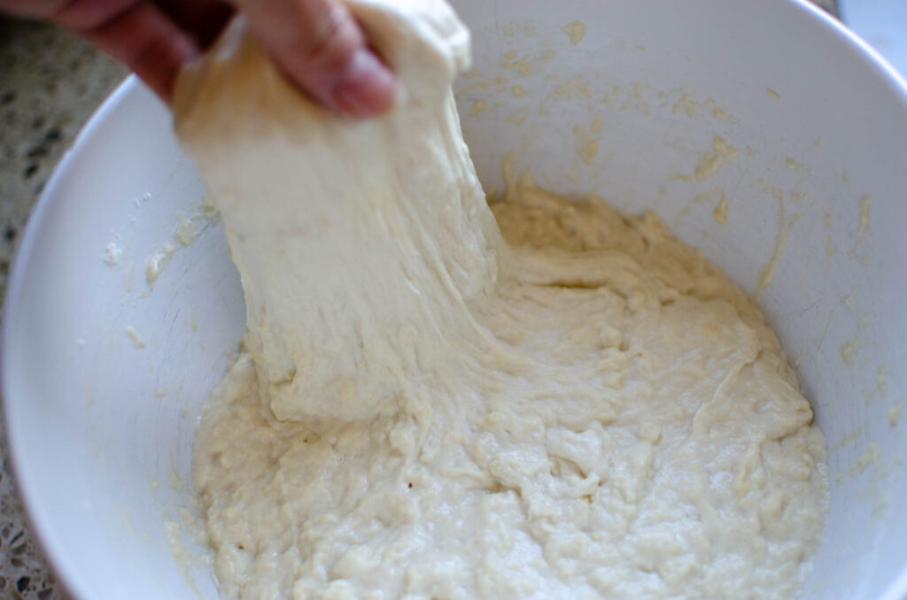 Hand stretching part of the sourdough ciabatta dough up.