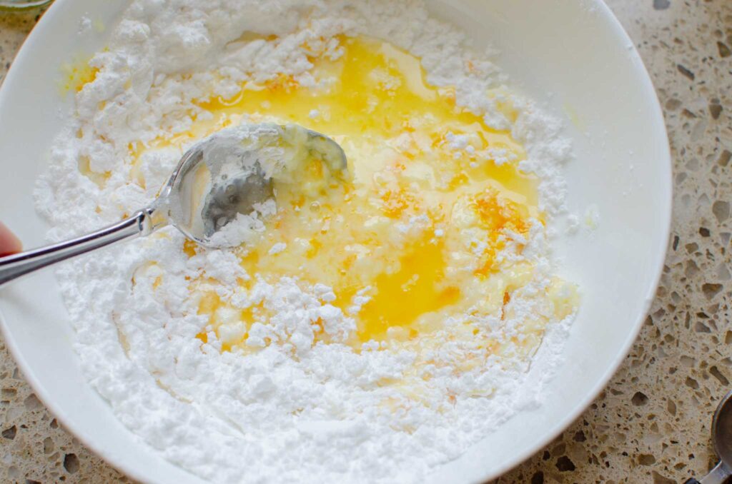 mixing the sweet orange glaze in a bowl with a spoon