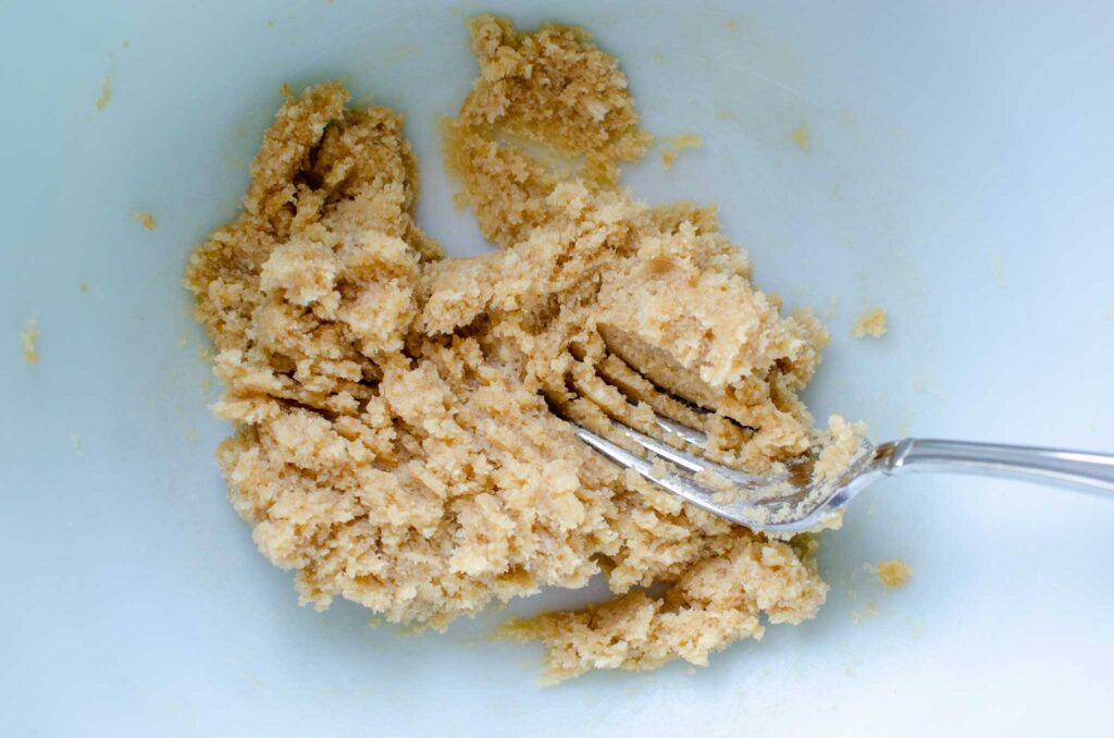 part of the crisp topping being mixed in large bowl for blueberry rhubarb crisp