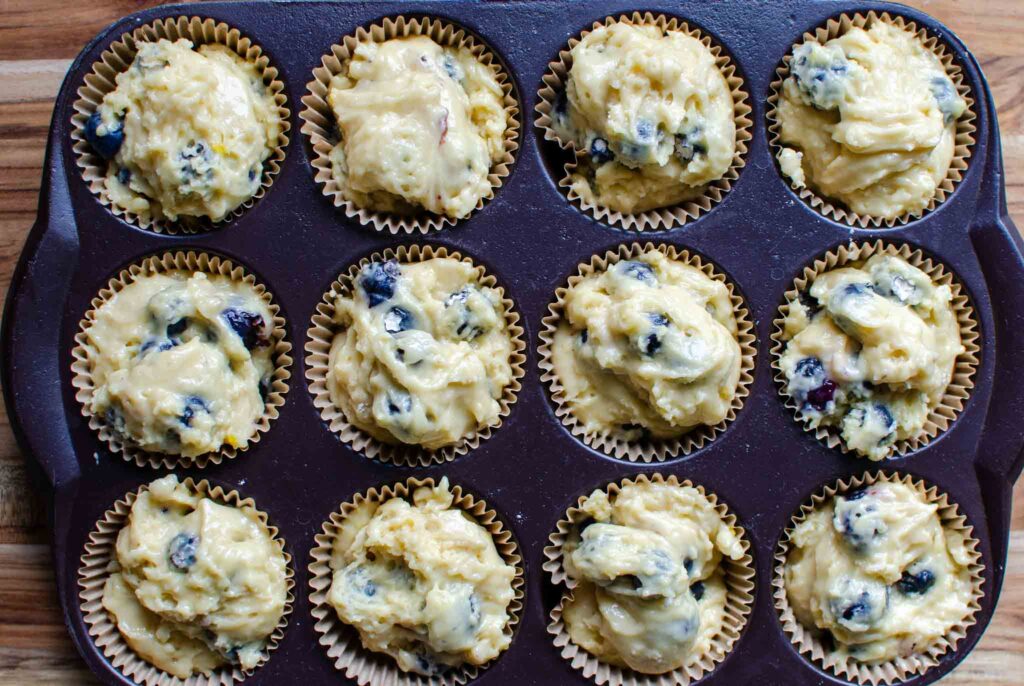 sourdough discard blueberry muffin batter in paper liners in muffin pan