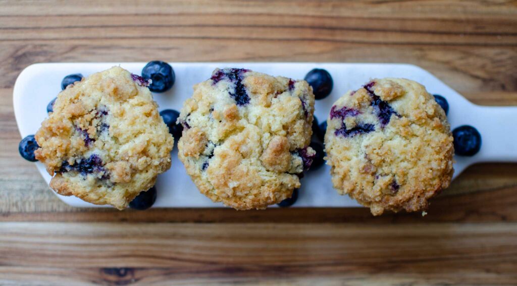 Three sourdough blueberry muffins on a mini stone serving tray