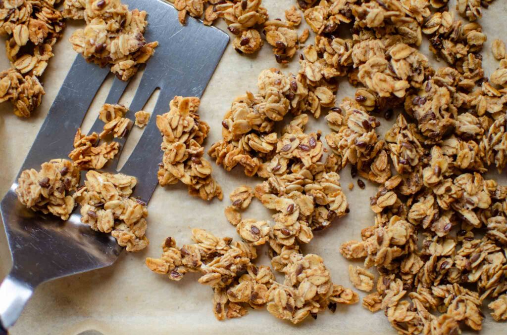  baked sourdough granola on parchment lined baking sheet