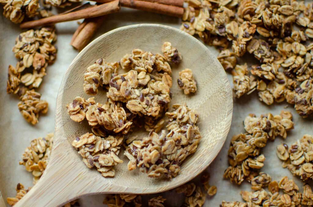 Big clusters of sourdough granola on wooden spoon