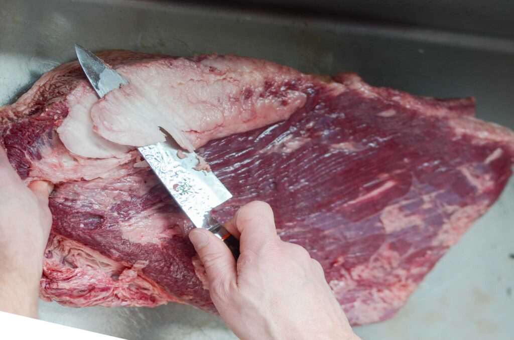 trimming the fat from the top of the brisket