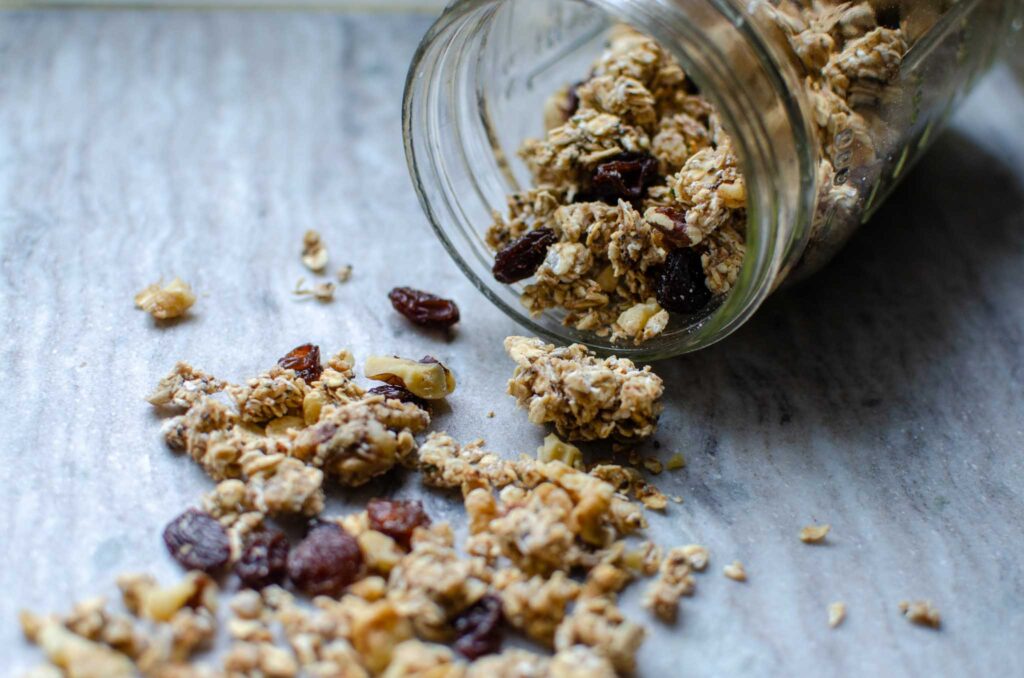 a mason jar tipped on its side with sourdough granola spilling out of it